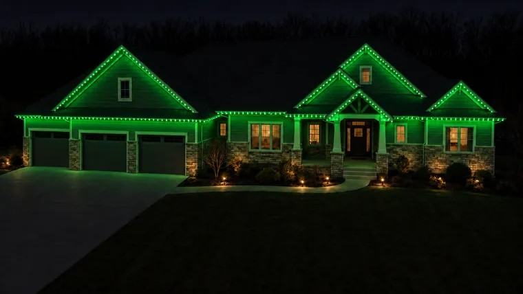 A home at night with permanent roofline lighting set to green