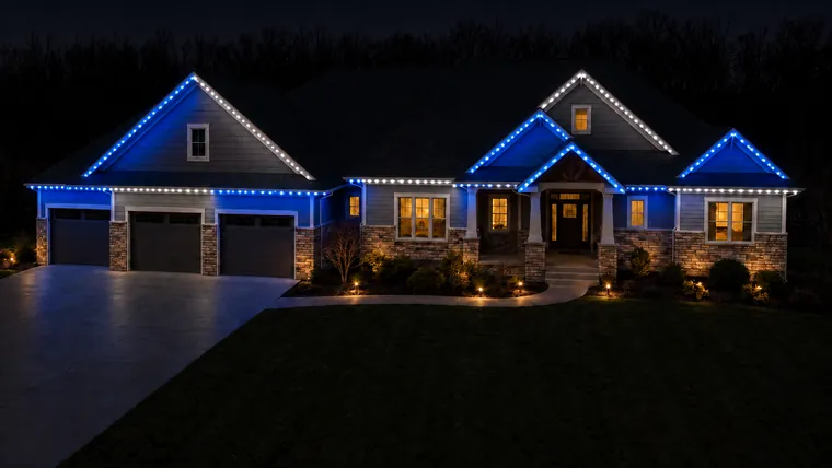 A home at night with permanent roofline lighting set to lions