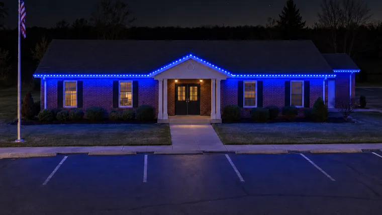 A township hall at night with permanent roofline lighting set to blue