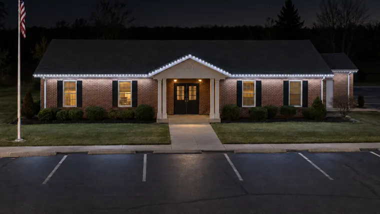 A township hall at night with permanent roofline lighting set to cool white
