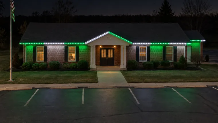 A township hall at night with permanent roofline lighting set to spartans