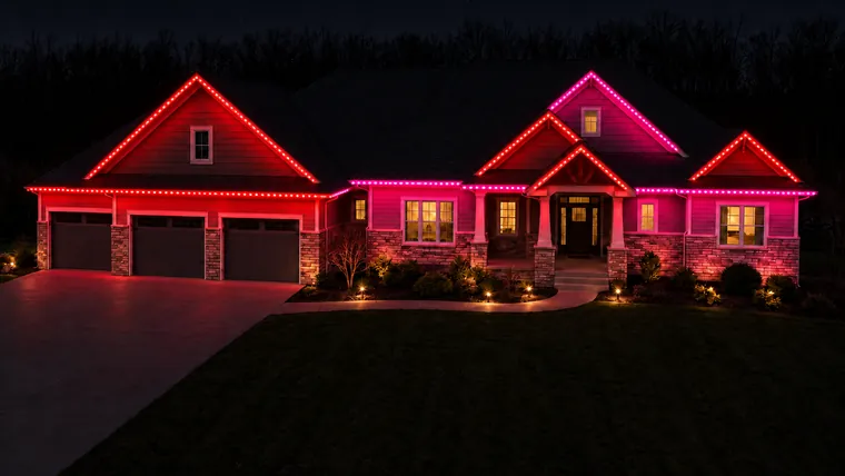 A home at night with permanent roofline lighting set to valentine's